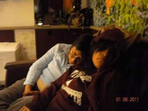 Liz & Doña Tere sleeping upright on a hospital couch, waiting for a baby to be born.